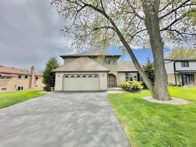 view of front facade featuring driveway, an attached garage, a front lawn, and roof with shingles