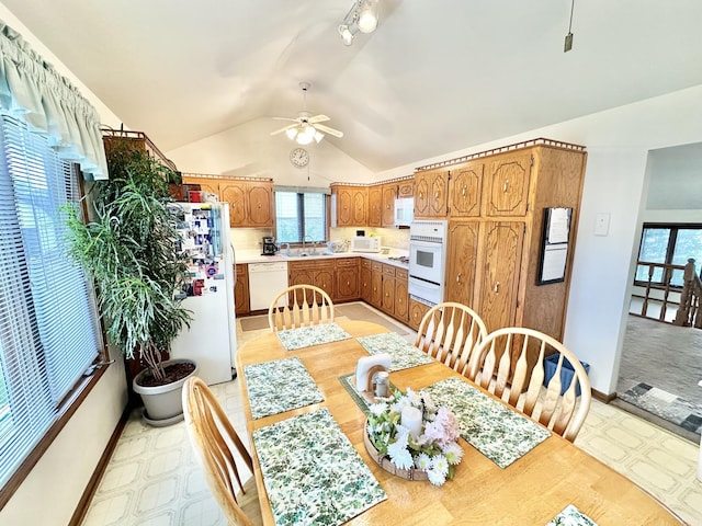 dining space with ceiling fan, lofted ceiling, and baseboards