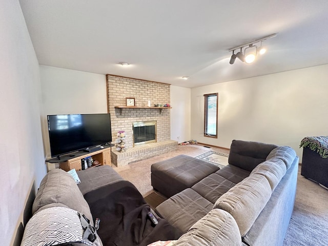 carpeted living room with rail lighting and a fireplace