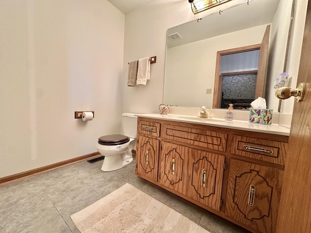 bathroom featuring baseboards, toilet, vanity, and tile patterned floors