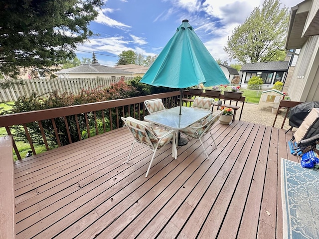 deck with outdoor dining area and fence