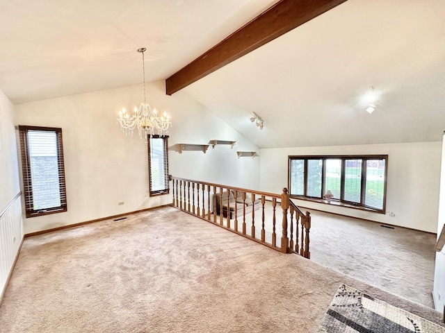 empty room featuring carpet flooring, healthy amount of natural light, and a chandelier