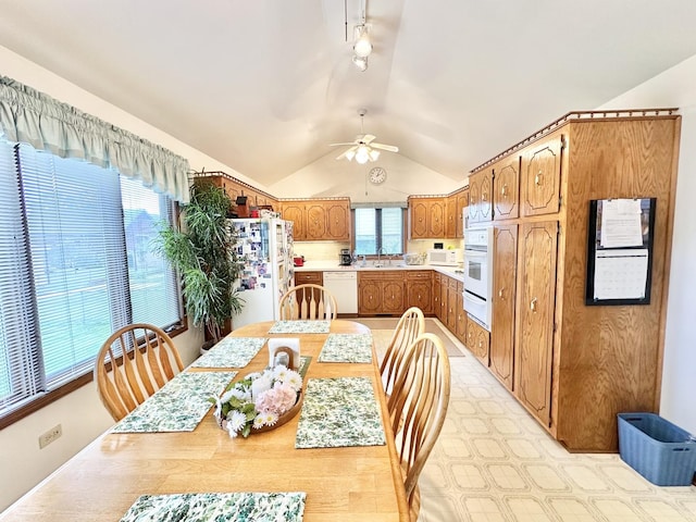 dining area featuring vaulted ceiling, a ceiling fan, and rail lighting