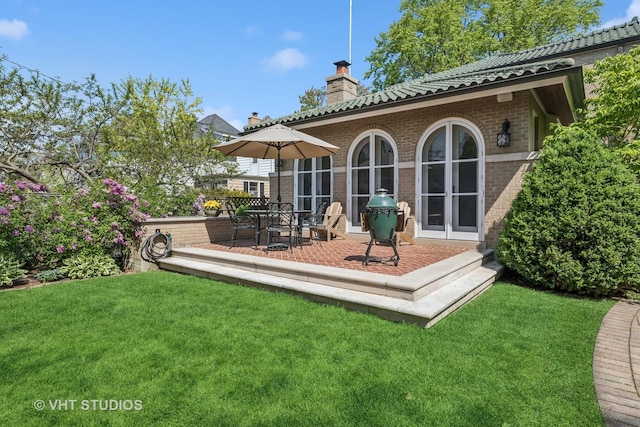 2037 Highland Ave, Wilmette, IL 60091 - back of house with a chimney, brick siding, a yard, and a tiled roof