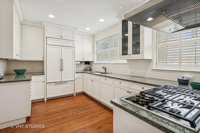 2037 Highland Ave, Wilmette, IL 60091 - kitchen with wall chimney range hood, stainless steel gas stovetop, white cabinets, light wood finished floors, and tasteful backsplash