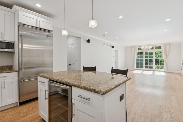 2501 N Sheffield Ave Unit 2S, Chicago, IL 60614 - kitchen featuring wine cooler, stainless steel appliances, light wood-style floors, a center island, and white cabinetry
