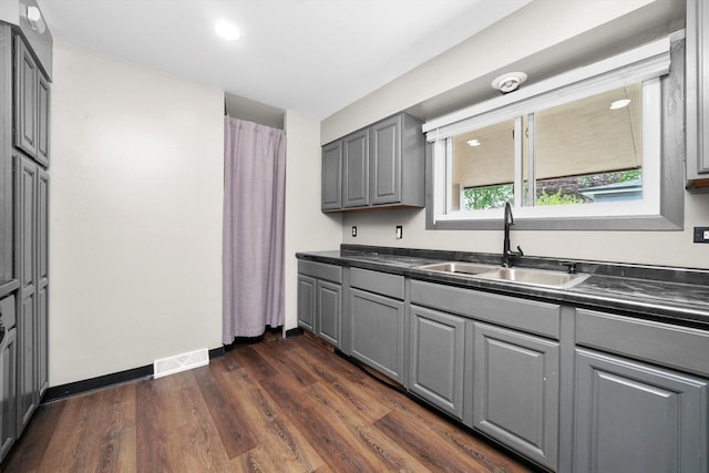 15245 Millard Ave, Midlothian, IL 60445 - kitchen with a sink, gray cabinets, dark countertops, dark wood-style flooring, and recessed lighting