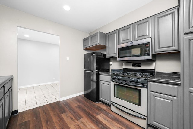 15245 Millard Ave, Midlothian, IL 60445 - kitchen featuring stainless steel appliances, gray cabinets, dark countertops, dark wood finished floors, and recessed lighting