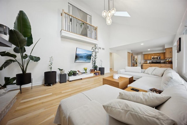 9013 Charing Cross Rd, Woodridge, IL 60517 - living area with light wood-style flooring, a towering ceiling, recessed lighting, and a skylight