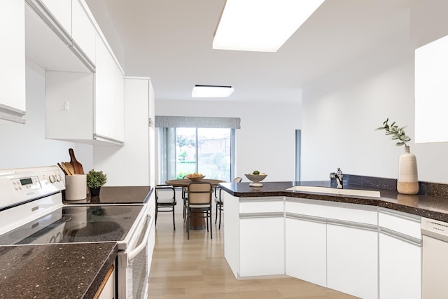 3070 Pheasant Creek Dr Unit 104, Northbrook, IL 60062 - kitchen with white appliances, a sink, a peninsula, white cabinetry, and light wood-style flooring