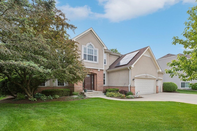 915 Eaton Ct, Lake Villa, IL 60046 - view of front facade featuring brick siding, stucco siding, concrete driveway, roof mounted solar panels, and a front yard