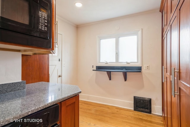 376 Douglas Ave, Crystal Lake, IL 60014 - kitchen with black appliances, ornamental molding, light wood-type flooring, brown cabinetry, and dark stone countertops
