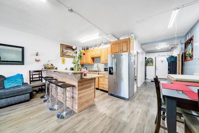 3724 W 135th St, Robbins, IL 60472 - kitchen with stainless steel refrigerator with ice dispenser, a breakfast bar area, light wood-style floors, a sink, and backsplash