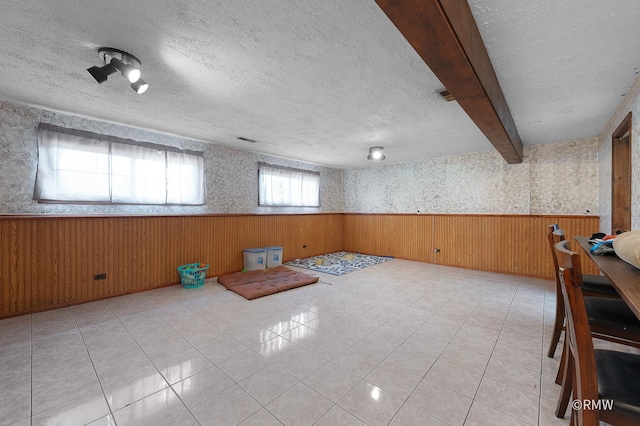 1236 N Fischer Dr, Addison, IL 60101 - empty room featuring a wainscoted wall, a textured ceiling, wood walls, light tile patterned floors, and wallpapered walls