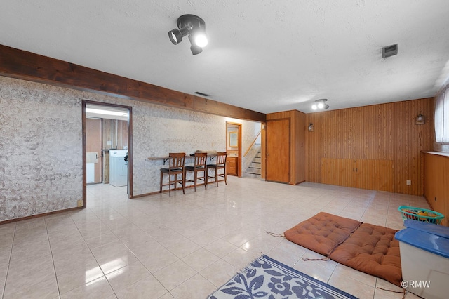 1236 N Fischer Dr, Addison, IL 60101 - basement with stairway, washer / dryer, a textured ceiling, wood walls, and light tile patterned flooring