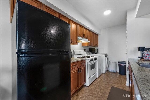 1565 Cornell Pl, Hoffman Estates, IL 60169 - kitchen with freestanding refrigerator, white gas stove, under cabinet range hood, light flooring, and brown cabinets