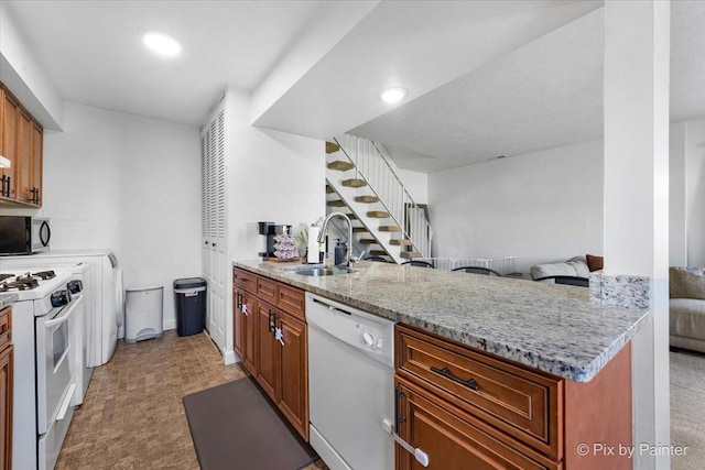 1565 Cornell Pl, Hoffman Estates, IL 60169 - kitchen with white appliances, a sink, a peninsula, light stone countertops, and brown cabinetry
