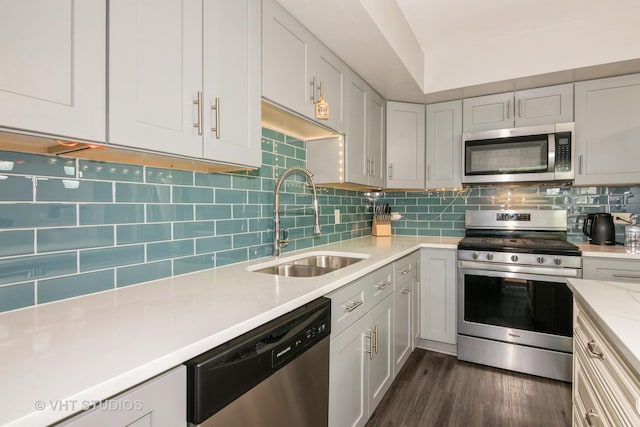 253 Edgewater Dr, Bloomingdale, IL 60108 - kitchen featuring appliances with stainless steel finishes, dark wood-type flooring, tasteful backsplash, and light stone countertops