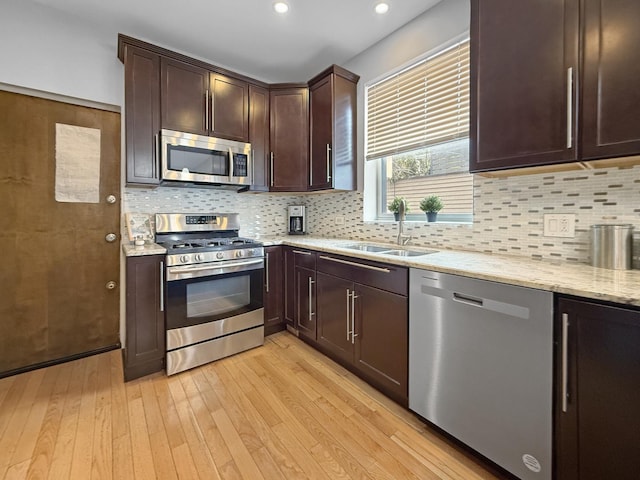 1325 W Addison St Unit 1A, Chicago, IL 60613 - kitchen featuring appliances with stainless steel finishes, a sink, light wood-style floors, dark brown cabinetry, and light stone countertops