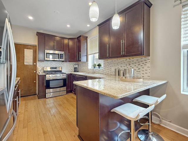 1325 W Addison St Unit 1A, Chicago, IL 60613 - kitchen with appliances with stainless steel finishes, light wood-style floors, light stone counters, a sink, and recessed lighting