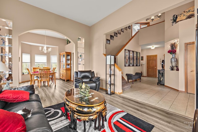 5008 Country Springs Dr, Johnsburg, IL 60051 - living area featuring arched walkways, wood finished floors, a chandelier, stairway, and a towering ceiling