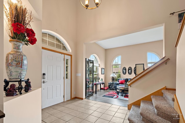 5008 Country Springs Dr, Johnsburg, IL 60051 - entrance foyer featuring light tile patterned floors, stairs, a towering ceiling, and a chandelier