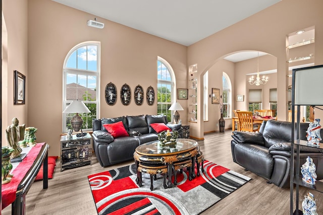 5008 Country Springs Dr, Johnsburg, IL 60051 - living room with arched walkways, wood finished floors, a chandelier, and a high ceiling