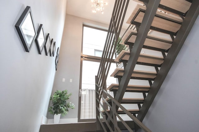 1529 W Chestnut St Unit 102, Chicago, IL 60642 - staircase featuring a chandelier, baseboards, and a towering ceiling
