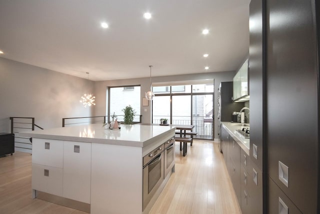 1529 W Chestnut St Unit 102, Chicago, IL 60642 - kitchen featuring a center island, white cabinetry, recessed lighting, light wood-style floors, and light countertops