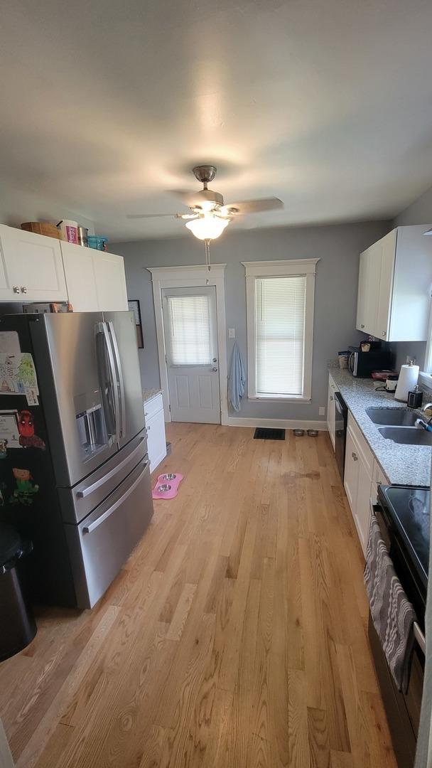401 Dixon Ave, Rock Falls, IL 61071 - kitchen with black appliances, a sink, white cabinets, light wood finished floors, and ceiling fan