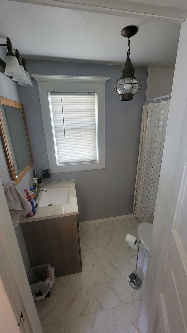 401 Dixon Ave, Rock Falls, IL 61071 - full bathroom with marble finish floors, vanity, a shower with curtain, toilet, and baseboards