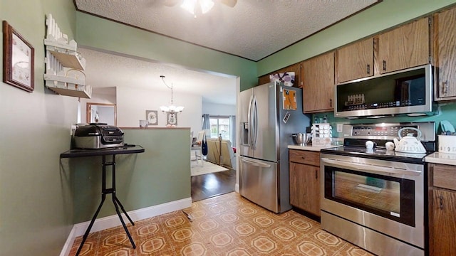 2702 Worcester Dr, Champaign, IL 61821 - kitchen with appliances with stainless steel finishes, a textured ceiling, a chandelier, light countertops, and brown cabinets