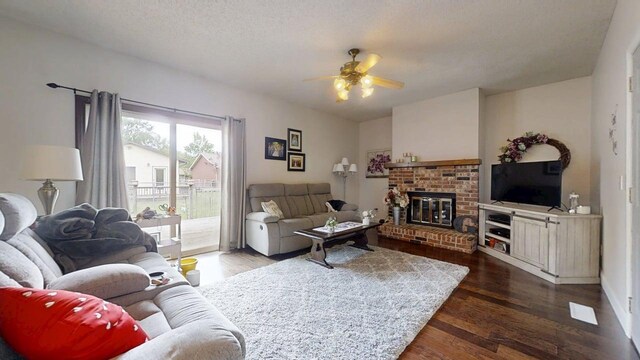 2702 Worcester Dr, Champaign, IL 61821 - living room with dark wood finished floors, a ceiling fan, and a brick fireplace
