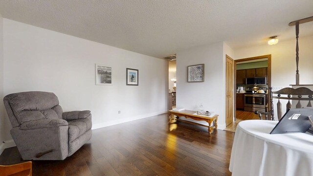 2702 Worcester Dr, Champaign, IL 61821 - living area with dark wood finished floors, a textured ceiling, and baseboards