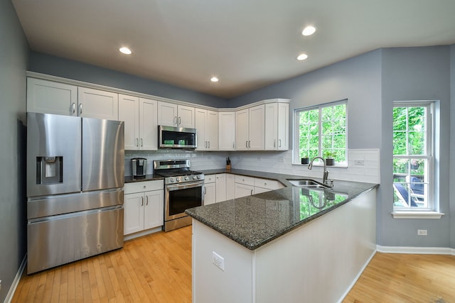 1817 2nd Pl, Saint Charles, IL 60174 - kitchen featuring appliances with stainless steel finishes, a sink, a peninsula, light wood finished floors, and white cabinetry