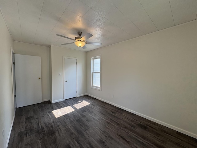 908 N Park St, Streator, IL 61364 - unfurnished bedroom featuring dark wood-style floors, baseboards, and a ceiling fan