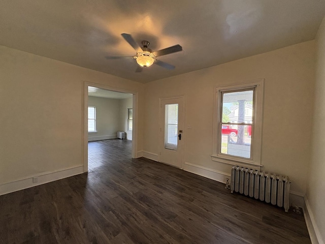 908 N Park St, Streator, IL 61364 - spare room featuring radiator heating unit, plenty of natural light, and dark wood finished floors
