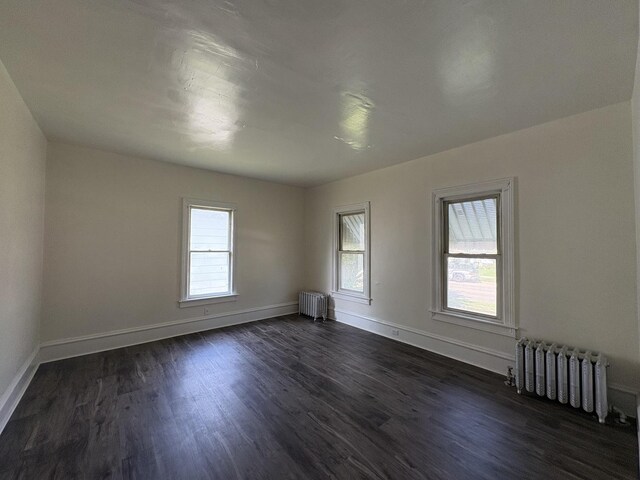 908 N Park St, Streator, IL 61364 - unfurnished room with radiator, dark wood-style flooring, and baseboards