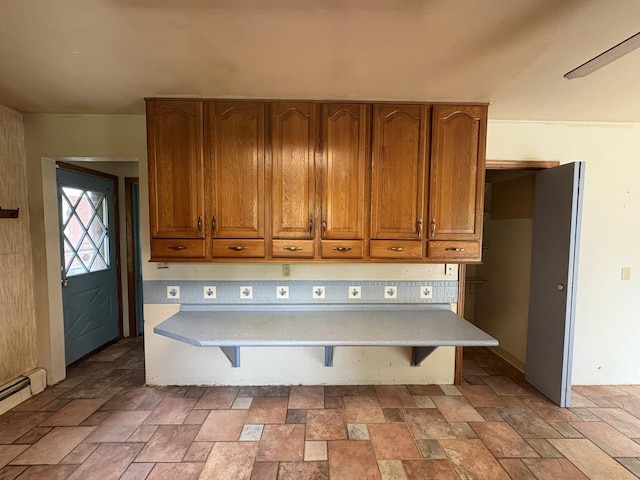 1515 Johnson St, Ottawa, IL 61350 - kitchen with brown cabinetry, light stone finish floors, light countertops, and baseboard heating