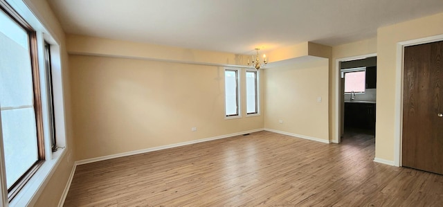 2338 S Canal St Unit H, Chicago, IL 60616 - unfurnished room featuring a chandelier, wood finished floors, a sink, and healthy amount of natural light