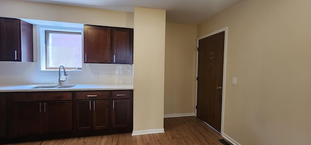 2338 S Canal St Unit H, Chicago, IL 60616 - kitchen featuring a sink, wood finished floors, light countertops, backsplash, and dark brown cabinetry