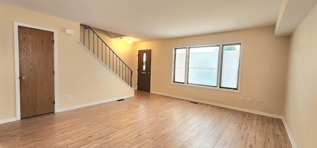 2338 S Canal St Unit H, Chicago, IL 60616 - unfurnished living room featuring light wood finished floors, stairs, and baseboards