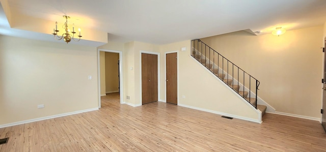 2338 S Canal St Unit H, Chicago, IL 60616 - unfurnished living room featuring stairs, wood finished floors, a chandelier, and baseboards