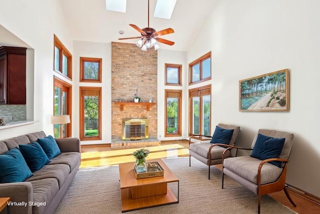 1337 E Thacker St, Schaumburg, IL 60173 - living area featuring high vaulted ceiling, a skylight, a brick fireplace, a ceiling fan, and wood finished floors