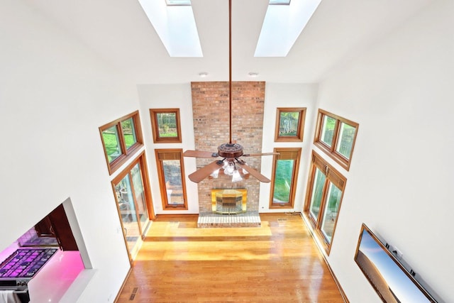 1337 E Thacker St, Schaumburg, IL 60173 - unfurnished living room with a skylight, a towering ceiling, wood finished floors, and a ceiling fan