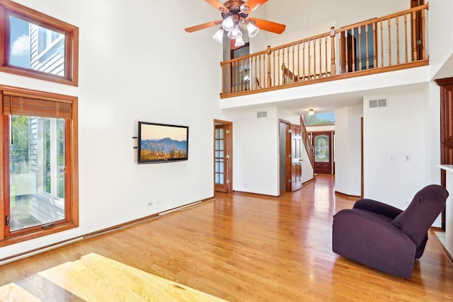 1337 E Thacker St, Schaumburg, IL 60173 - living room featuring a towering ceiling, light wood-style floors, ceiling fan, and baseboards