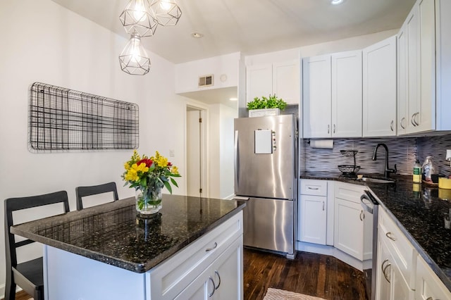 2512 N Marshfield Ave, Chicago, IL 60614 - kitchen with appliances with stainless steel finishes, a sink, dark wood finished floors, a breakfast bar, and white cabinetry