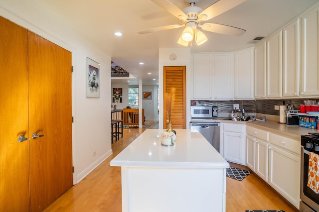 2512 N Marshfield Ave, Chicago, IL 60614 - kitchen featuring stainless steel appliances, ceiling fan, light countertops, backsplash, and light wood-type flooring