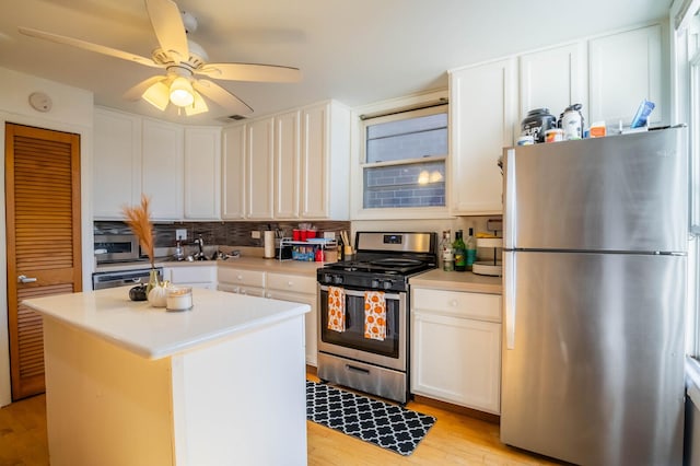 2512 N Marshfield Ave, Chicago, IL 60614 - kitchen with stainless steel appliances, white cabinetry, light wood-style floors, backsplash, and light countertops