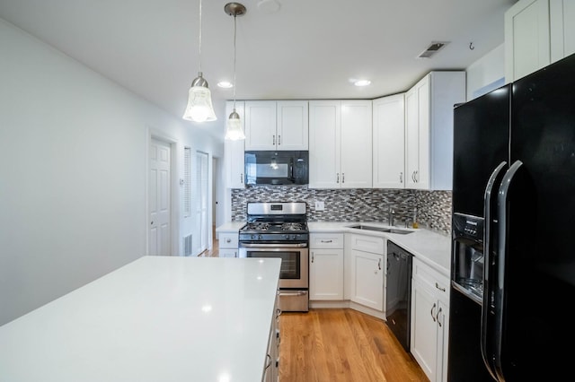 2512 N Marshfield Ave, Chicago, IL 60614 - kitchen with black appliances, a sink, light countertops, backsplash, and light wood finished floors